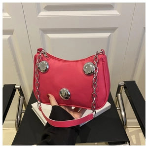 Detail of rose pink shoulder bag with large silver metal studs and chain strap handle