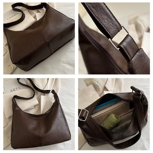 Detail of dark brown hobo bag with vintage pleated texture and silver metal buckles