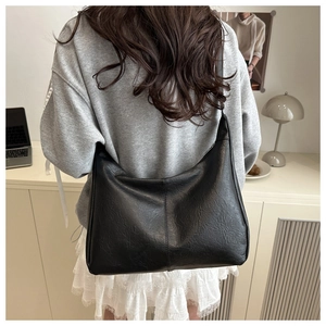 Vue détaillée de la texture en cuir vintage souple et de la forme demi-lune du grand sac hobo