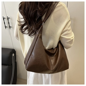 Detailed view of dark brown oversized hobo bag with vintage texture and reinforced stitching