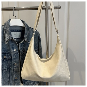 Detailed close-up of cream-white large tote bag showing textured synthetic leather finish