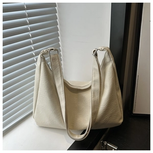 Détail du sac hobo blanc cassé montrant son similicuir texturé et ses larges bretelles