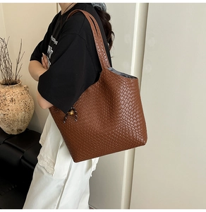 Détail du tissage sur sac cabas marron avec breloque décorative en perles de métal
