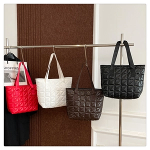 Quilted nylon tote bags in red, white, brown and black hanging on a display rack