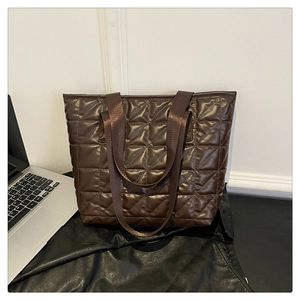 Close-up of dark brown quilted tote bag showing large diamond stitching and satin finish