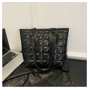 Detailed view of the black quilted tote bag with diamond stitching and glossy finish