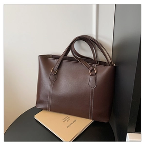 Détail du sac cabas en cuir PU marron foncé avec surpiqûres et boucle en métal doré