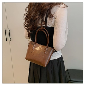 Modèle portant un grand sac cabas vintage marron foncé en similicuir, vue de dos