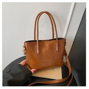 Détail d'un grand sac cabas marron en cuir avec texture vintage et bandoulière amovible