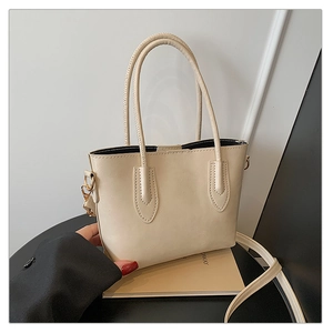 Détail du cabas blanc crème avec texture en cuir PU souple et finitions dorées brillantes
