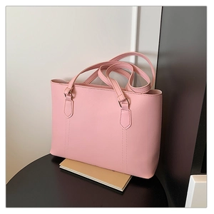 Sac fourre-tout minimaliste en cuir PU rose avec surpiqûres sur un support de studio