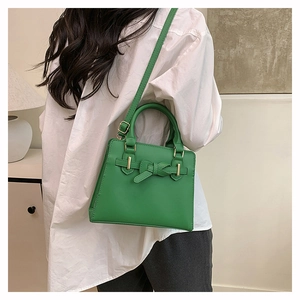 Sac bandoulière vert avec détail nœud et bandoulière réglable, porté par un mannequin