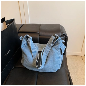 Vista dettagliata della borsa hobo in denim azzurro con fibbia metallica e trama morbida