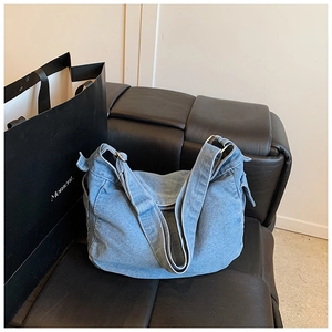 Dettaglio borsa a tracolla in denim celeste con tracolla regolabile e fibbia argento