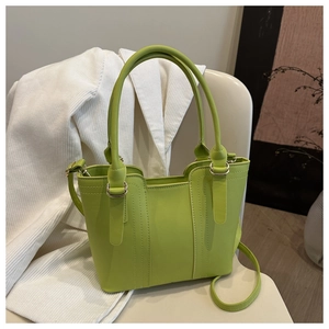 Detail of luxury green leather tote with silver hardware and parallel stitching