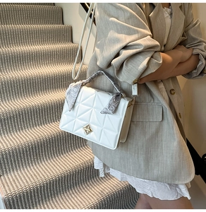 Détail du sac carré matelassé blanc avec poignée en soie et fermoir doré rotatif