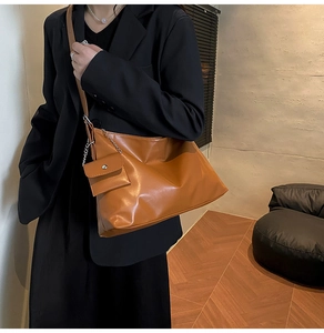 Brown leather tote bag with a matching mini pouch, perfect for office commuting and travel