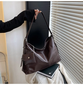 Detail of deep brown Hobo tote bag with smooth PU leather and mini coin purse pendant