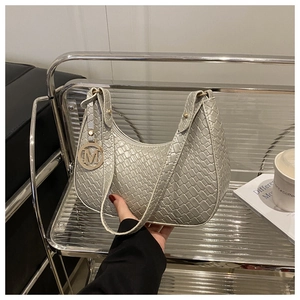 Detailansicht der silbergrauen Unterachseltasche aus Kunstleder mit Krokoprägung und M-Anhänger