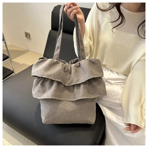 Detailweergave van de donkergrijze shopper met gelaagde ruches en brede stoffen handvatten