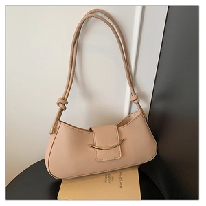 Detail of nude beige half-moon shoulder bag with golden metal clasp and knot strap
