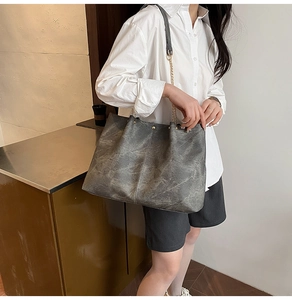 Détail du grand sac cabas avec texture marbrée vintage et bandoulière en chaîne dorée