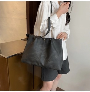 Detail of the vintage dark grey tote bag featuring vertical stitching and chain strap