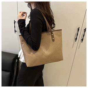 Detail of the woven texture and golden rivets on this large apricot tote bag