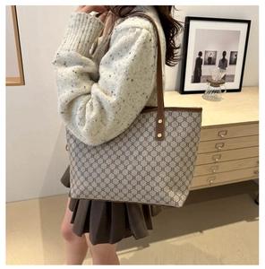 Détail du cabas rétro avec imprimé géométrique, bordures en cuir et rivets métalliques