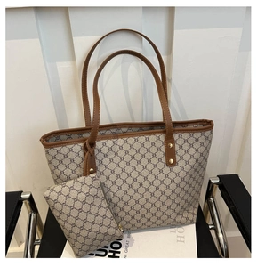 Détail du sac cabas vintage avec motif géométrique et mini pochette sur fauteuil en cuir