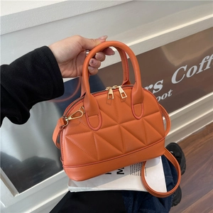 Borsa trapuntata arancione a conchiglia con dettagli dorati e tracolla rimovibile