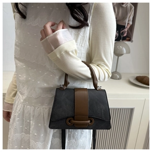 Detail of vintage square canvas bag with brown leather straps and metal buckle closure