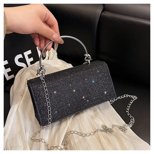 Detail showing the black sparkling rhinestones and silver circular handle on the evening clutch