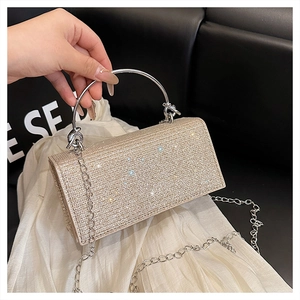 Detail of champagne gold evening clutch with rhinestones and silver metal handle