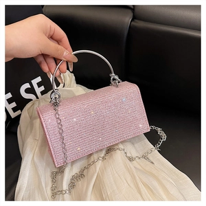 Detailed shot of pink rhinestone clutch bag with silver metal handle and chain strap