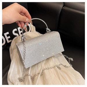 Detail showing the silver rhinestone handbag with metallic ring handle and chain strap
