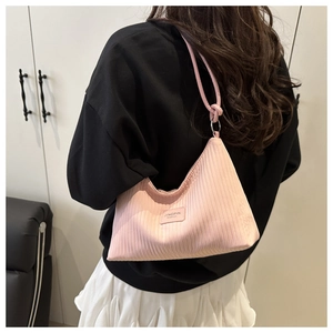 Detail of pink pleated corduroy tote bag featuring vertical texture and brand logo