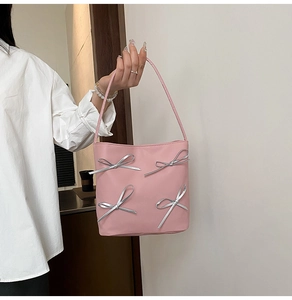 Gros plan détaillé d'un sac à main rose avec des nœuds argentés 3D et des anses fines
