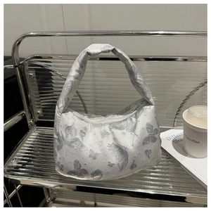Detail of silver butterfly embroidery on a white large-capacity hobo shoulder bag