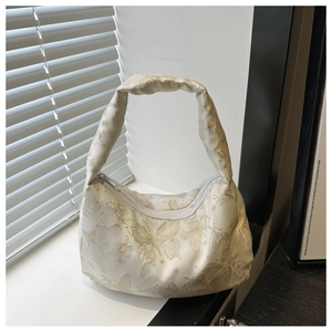 Detail of white butterfly shoulder bag showing golden metallic jacquard and strap