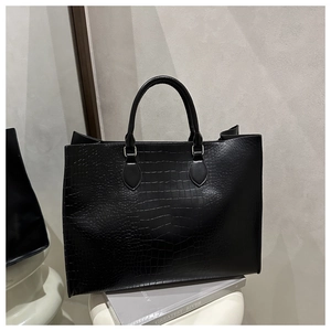 Close-up of the black crocodile pattern texture and handle of the large tote bag