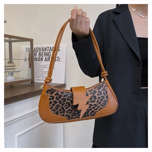 Détail du sac léopard avec fermoir doré en forme d'éclair et finitions en cuir