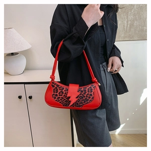 Gros plan du sac léopard avec détail d'éclair en cuir rouge et bandoulière nouée