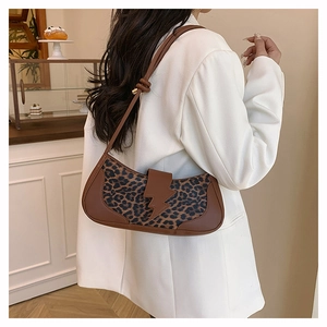 Détail du sac léopard vintage avec boucle en forme d'éclair sur un blazer blanc