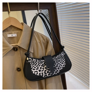 Détail du sac baguette léopard avec boucle éclair noire sur un trench-coat kaki classique