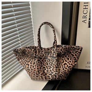 Macro detail of high-quality leopard print tote bag with metallic hardware and shadow effect