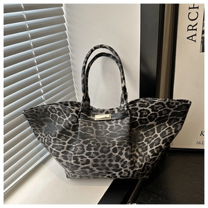 Macro shot of leopard print tote featuring gold hardware buckle and textured finish