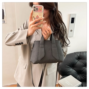 Detailed close-up of dark grey striped faux leather tote bag with unique wide handle