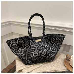 Detail of the leopard print tote bag with rectangular metal plaque and textured handles
