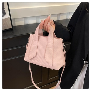 Detail showing the light pink tote bag with textured diagonal patterns and silver metal hooks